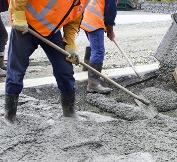 Three Construction Workers Moving Concrete