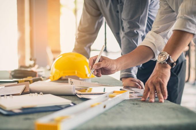 two construction workers review a schematic