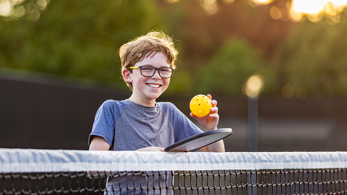 Boy on court with pickleball gear