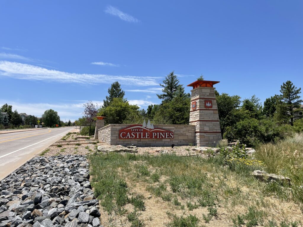 Stone monument with the City of Castle Pines logo at the entrance to the city on Monarch Boulevard.