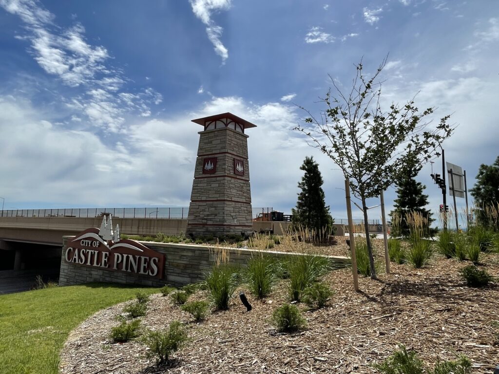Stone monument with the City of Castle Pines logo at the entrance to the city at southbound I-25 and Castle Pines Parkway.