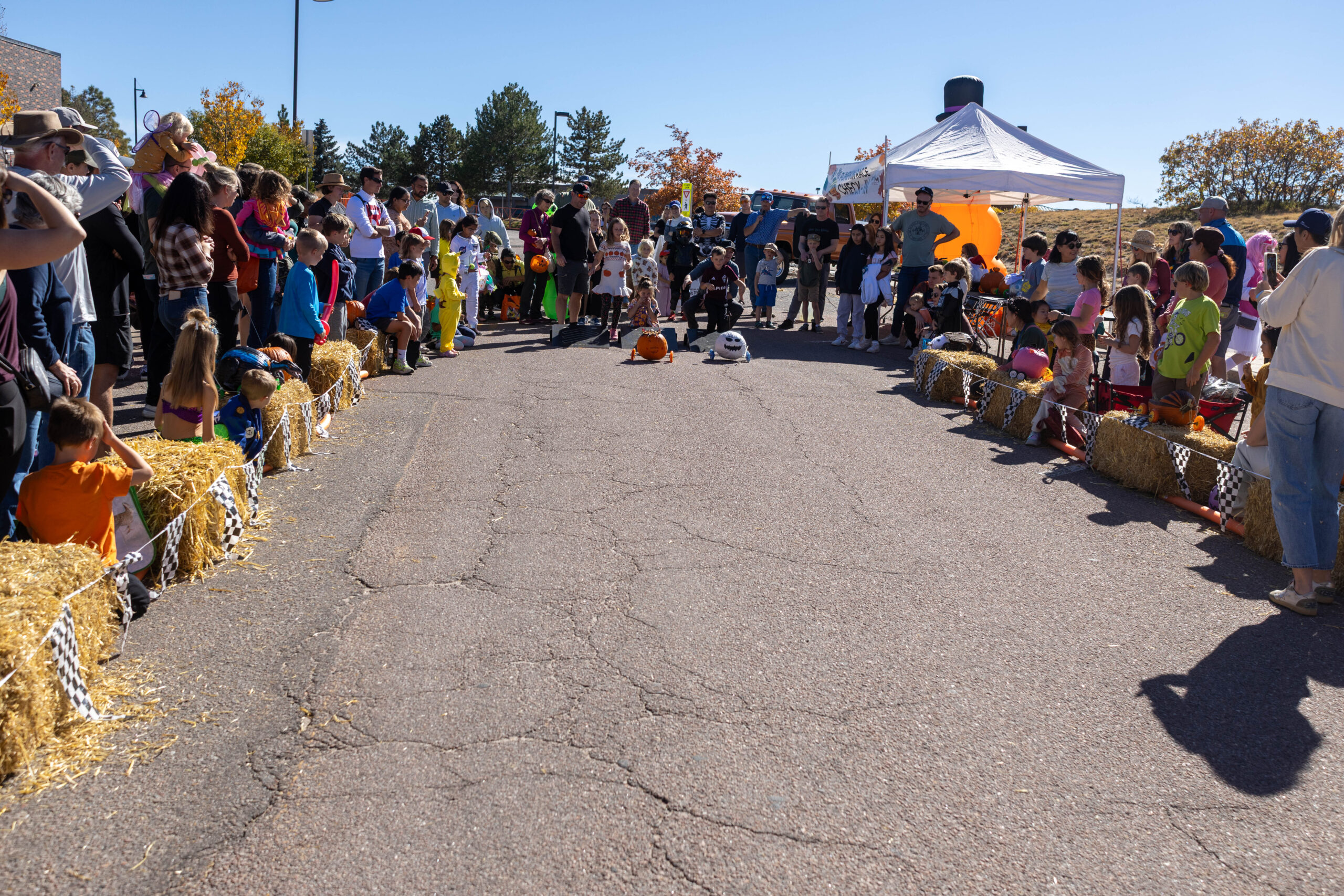 Large group of people watching two pumpkins race.