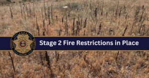 Brown grass and brush with a blue banner that reads "Stage 2 Fire Restrictions". The Douglas County Sheriff's logo is also on the banner.